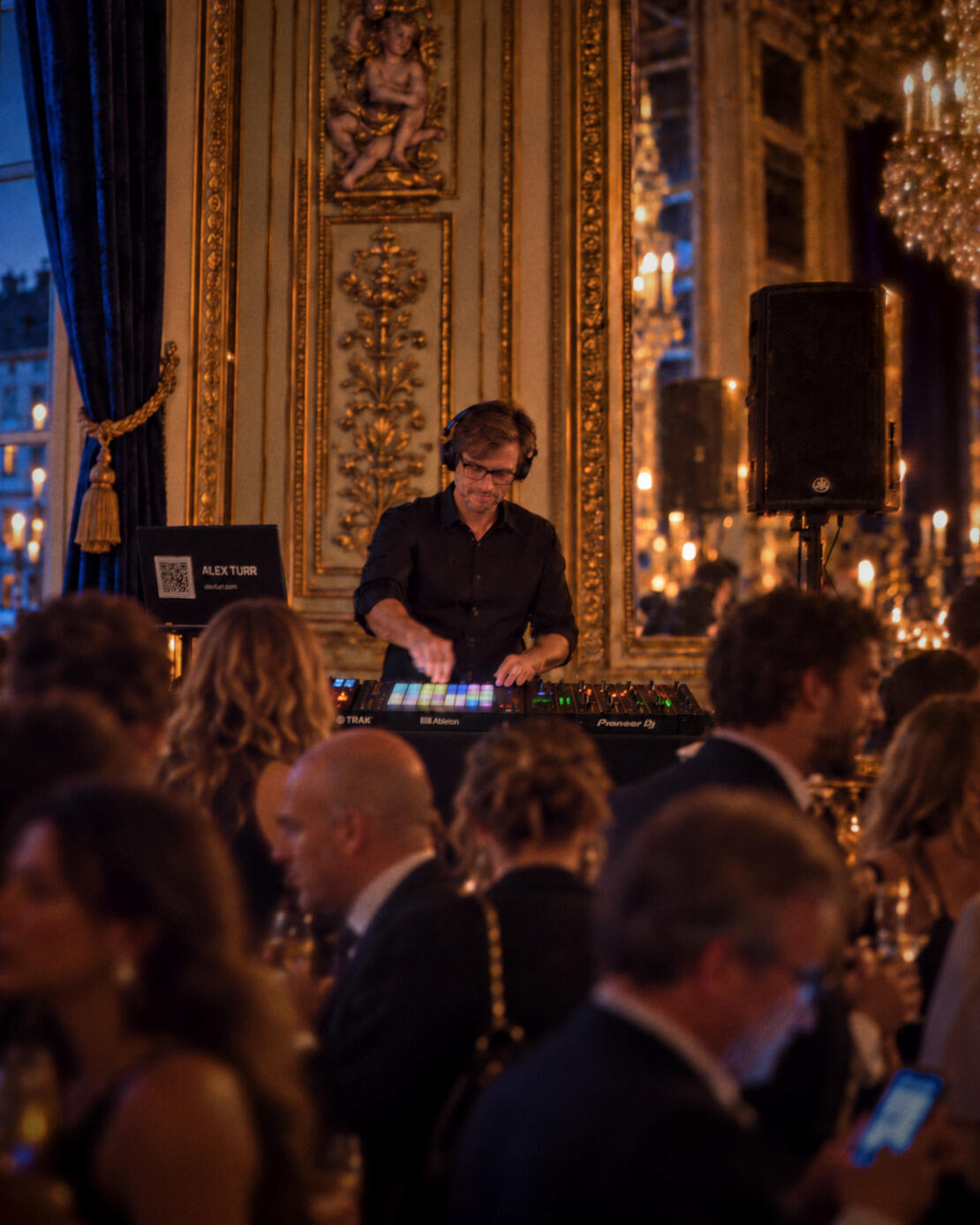 Alex Turr mixe lors d'un cocktail dans un élégant salon de réception parisien.